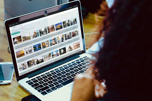 Eine Person betrachtet Stockfotos auf einem Laptop.