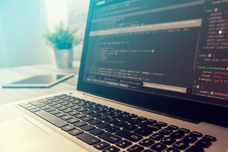 A laptop with HTML code on it.