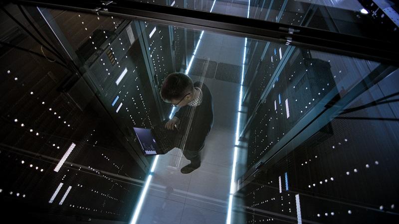 A man checks the servers of a data center with his laptop.