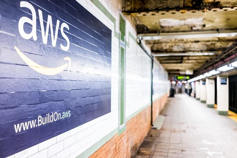 A picture of the Amazon AWS logo painted on a brick wall.