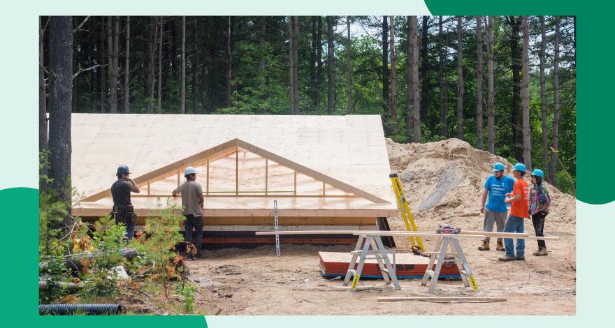 Menschen bei der Arbeit an einem teilweise errichteten Haus von Habitat for Humanity Canada.