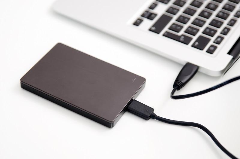 Eine externe Festplatte, die an einen Laptop angeschlossen ist.