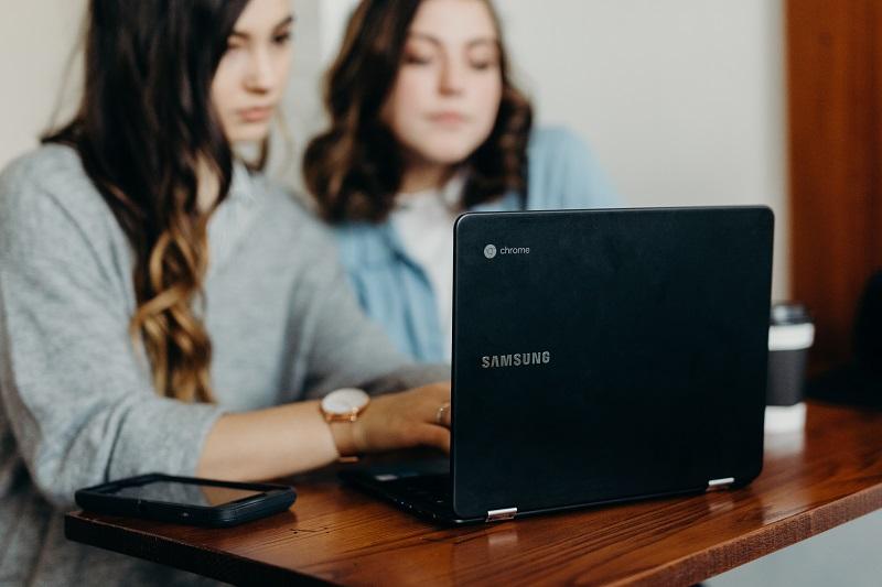 Two young women using a laptop.