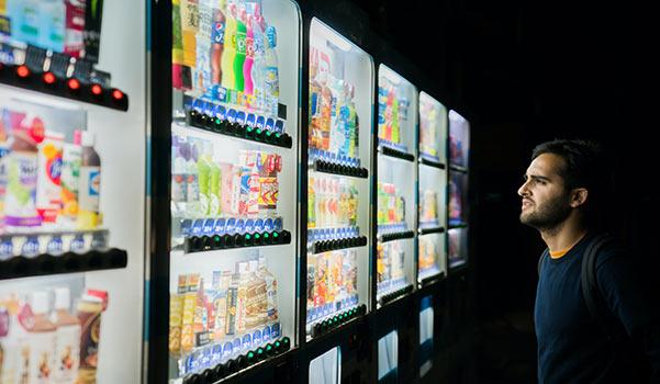 A customer making a food selection from vending machines.