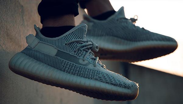 A person wearing Yeezy shoes off a ledge.