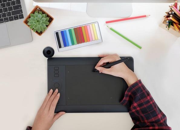 Eine Abbildung eines Designers, der auf einem digitalen Pad zeichnet.