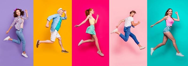 Happy people jumping on colored backgrounds.
