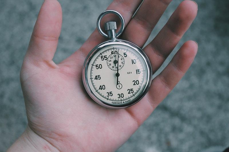 A hand holding a stopwatch.
