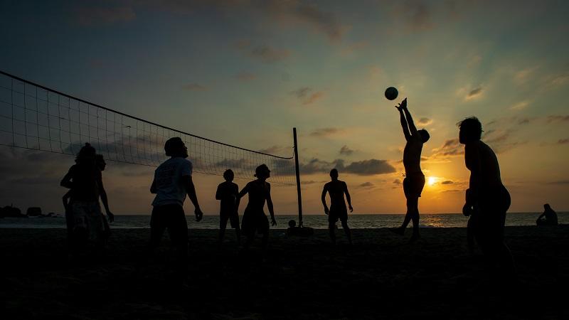 A group of people playing beach volleyball.