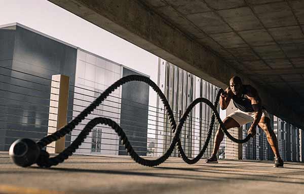 A man swinging an exercise rope.