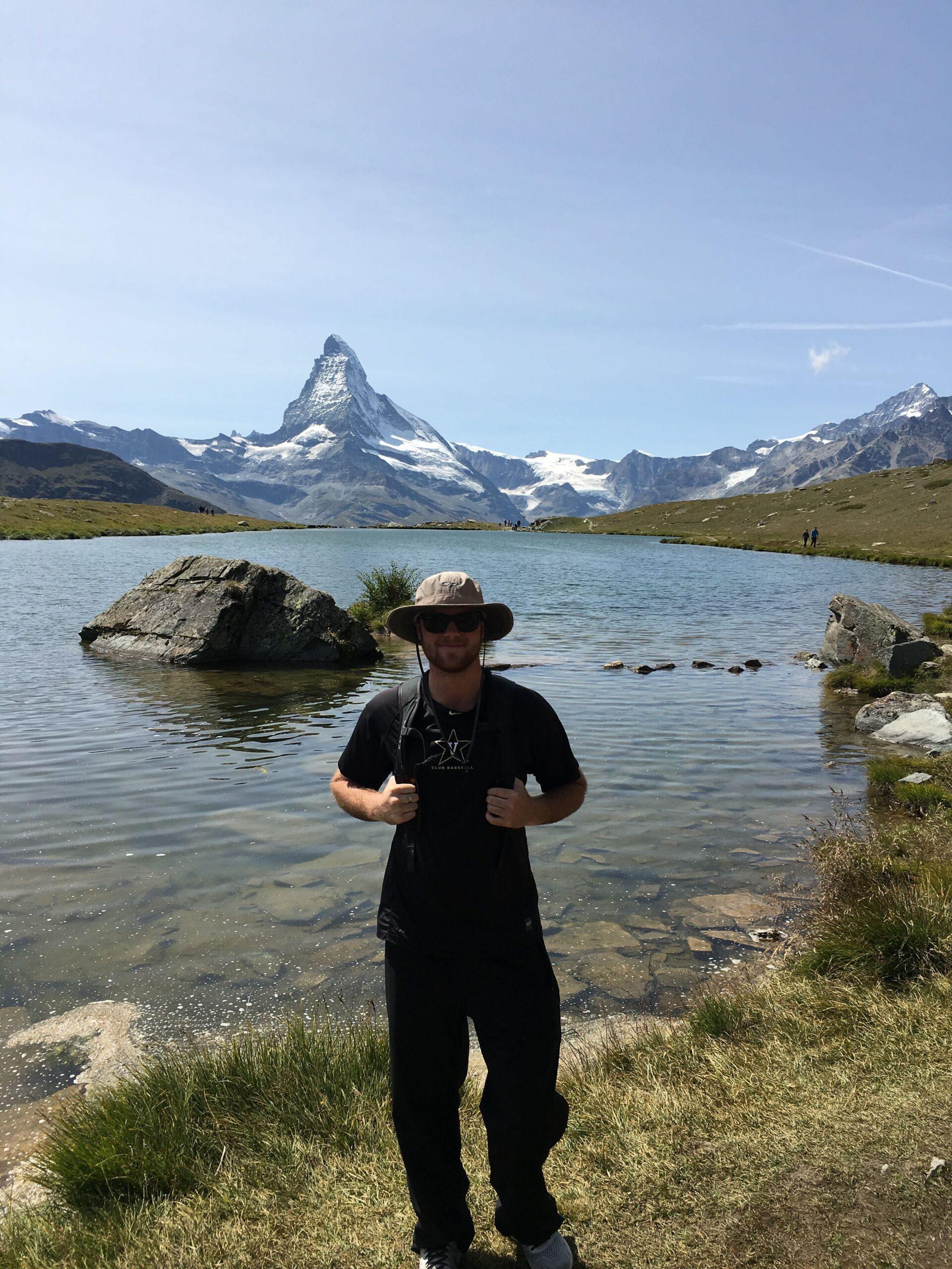 Tyler Jacks next to a river on a hiking trip.