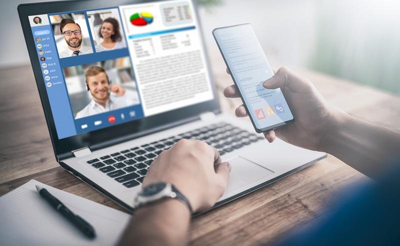 A worker has a meeting on his laptop.