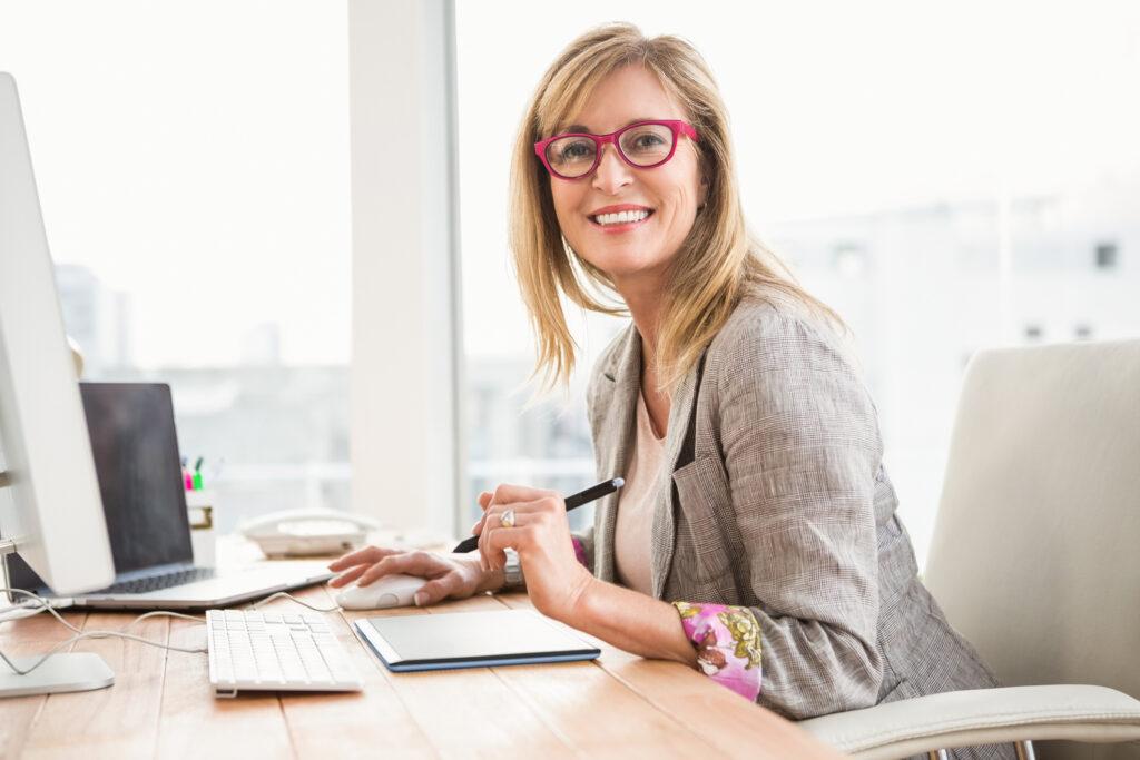 Woman sitting at a desk, working on a computer.