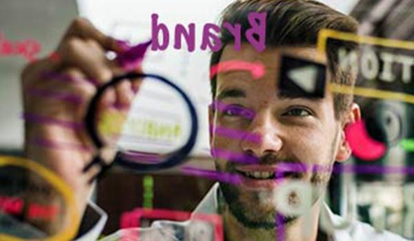 Ein Mann zeichnet etwas auf ein transparentes Whiteboard.