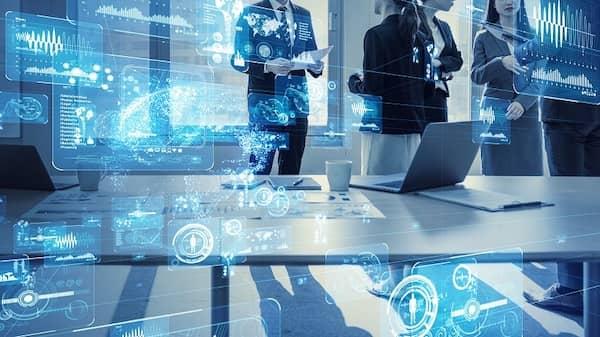 Eine Gruppe von Arbeitskollegen umgeben von Computerdaten zum Thema digitale Transformation.