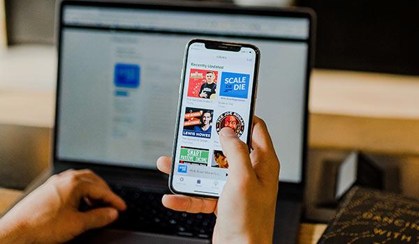 Eine Person recherchiert auf einem Smartphone zum Thema ‘die besten Branding-Podcasts’.