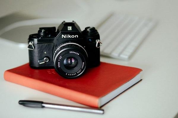 Eine Nikon-Kamera liegt auf einem Tagebuch.