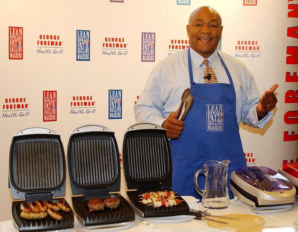 A picture of George Foreman by his signature grill.