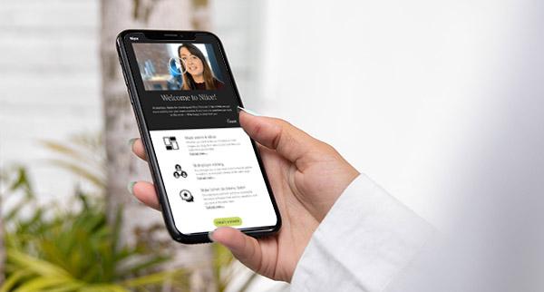 Hand holding a smartphone displaying a video marketing email.