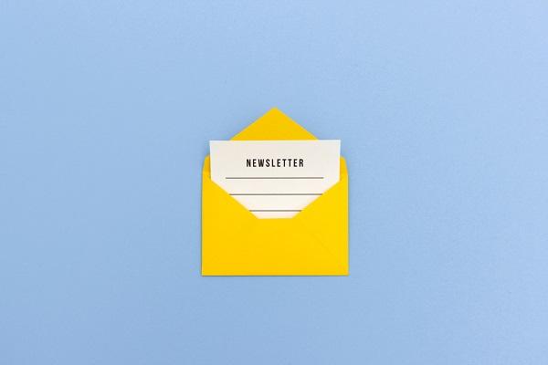 Ein gelber Briefumschlag, aus dem ein Blatt ragt, das mit dem Wort Newsletter überschrieben ist.