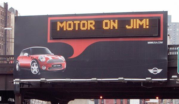 Personalisierte Werbetafel von Mini Cooper mit einer digitalen Anzeige, die besagt: 'Fahr weiter, Jim'.