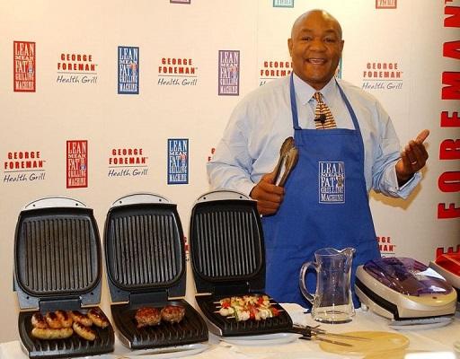 Ein Bild von George Foreman neben seinem Markenzeichen, dem Grill.
