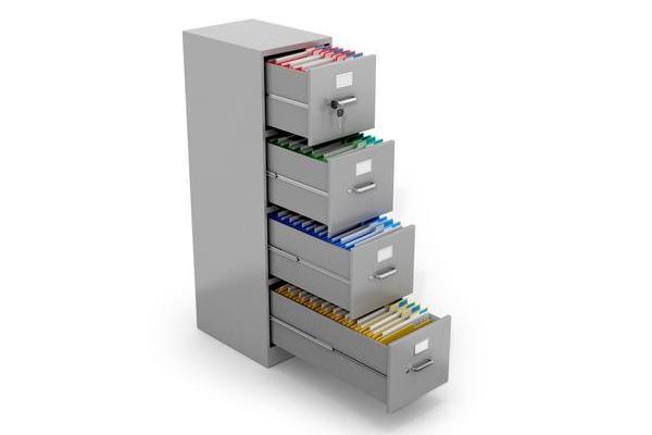 Farblich sortierte Ordner in einem Aktenschrank.