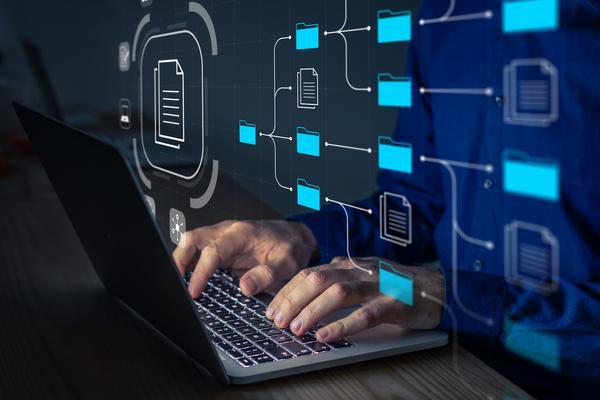 Darstellung eines Mannes, der am Laptop organisierte Dateien durchsucht.