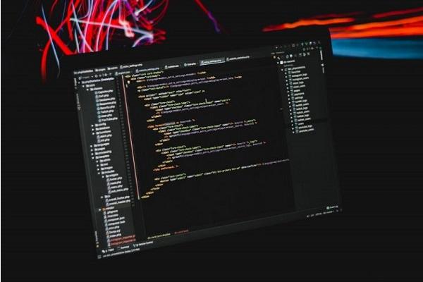 Ein Computer, über dem farbige digitale Ströme schweben.