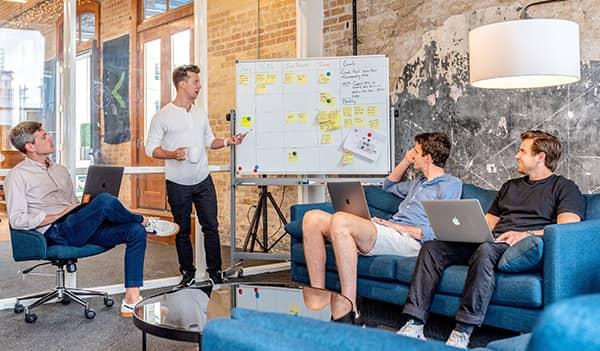 Eine Besprechung unter jungen Kollegen zur strategischen Planung für das E-Mail-Capturing in einem modernen Büro.