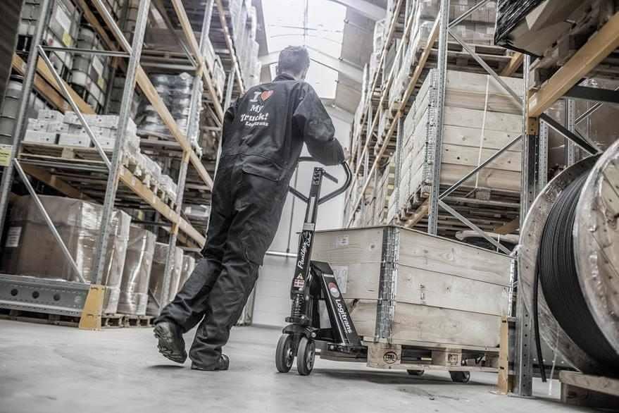 Screenshot of a Logitrans asset in Canto, showing a person in a coverall pushing a loaded cart through the warehouse.