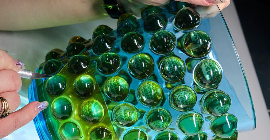 A delicate glass vase receives finishing touches by an artist in the workshop of Lalique.