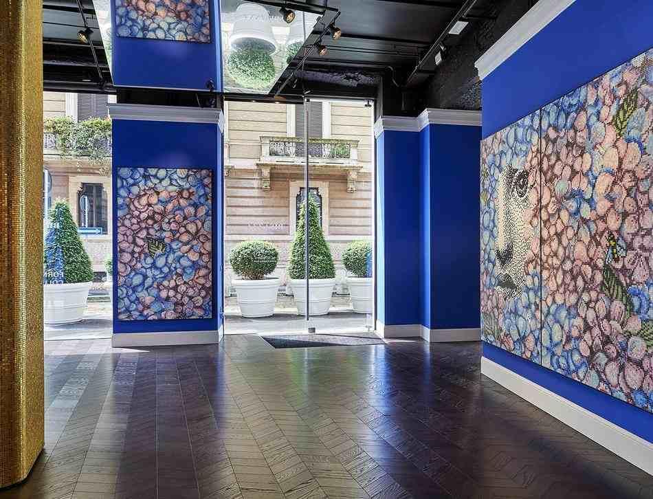 A photograph of the Bisazza store in Milan, Italy, with the walls decked out in beautiful mosaics on a dark blue background.
