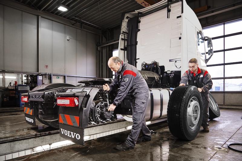 Ferronordic employees change a tire on a cargo truck.