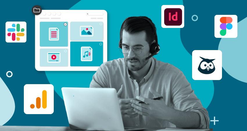 Man wearing a headset reviewing digital files on a laptop with Slack, Adobe, Figma, and analytics icons, representing digital asset manager jobs focused on collaboration and integrations.