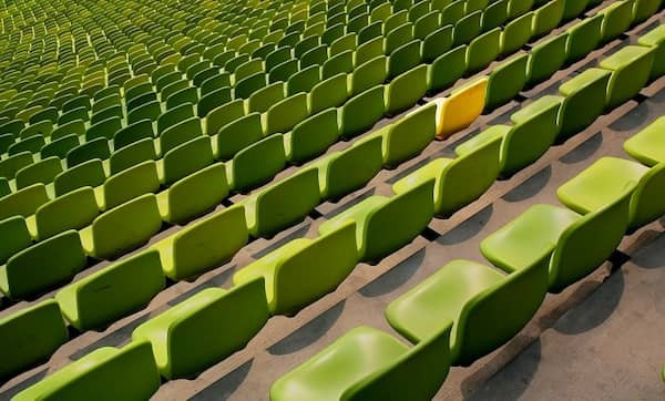 Ein Stadion mit grünen Sitzplätzen und einem gelben Sitz.