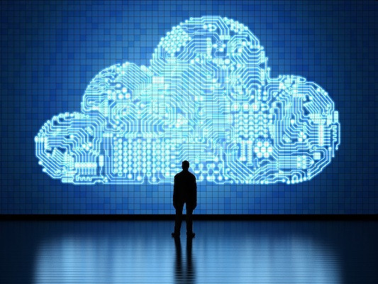 Eine Person steht vor einer großen digitalen Wolke.