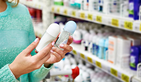Eine Person entscheidet sich zwischen zwei unterschiedlichen Produkten in Flaschen.