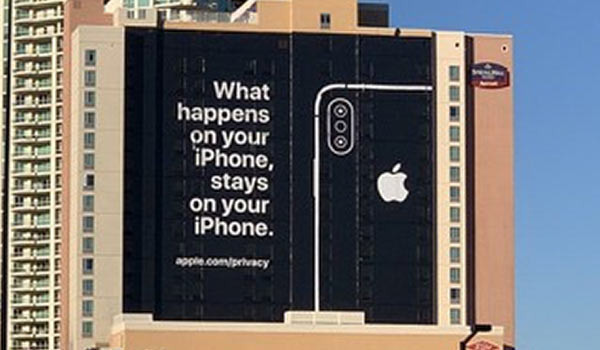 Eine Werbeanzeige für das iPhone an der Fassade eines hohen Gebäudekomplexes.