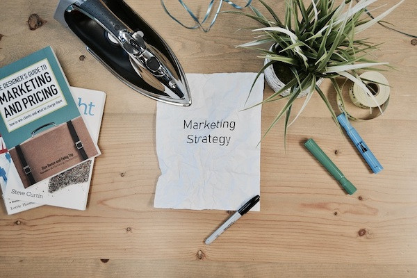 Auf einem Zettel steht das Wort 'Marketingstrategie'.