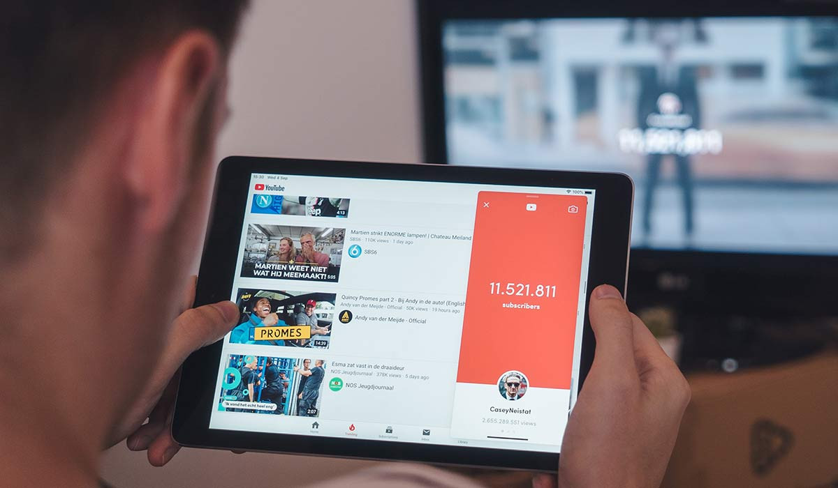 Eine Person schaut über ein Tablet ein Youtube-Markenprofil an.