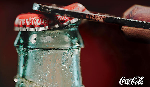 Eine Coca-Cola-Flasche wird geöffnet.