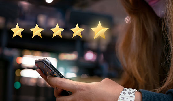 Eine Person hinterlässt über ihr Smartphone eine Bewertung.