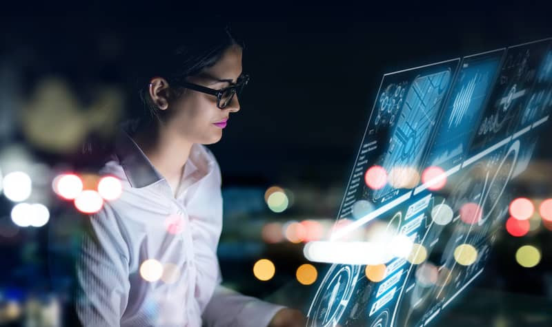 Eine Mitarbeiterin arbeitet an einer futuristischen, transparenten Konsole.