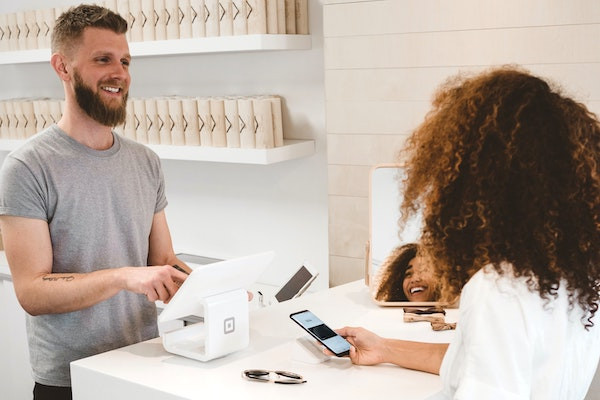 Der Inhaber eines trendigen kleinen Geschäfts trägt die E-Mail-Adresse eines Kunden für sein lokales E-Mail-Marketing in seine Liste ein.