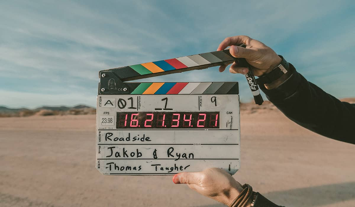Eine Filmklappe mit Informationen bei einem Außendreh.