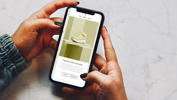 Zwei Hände halten ein Smartphone, auf dem eine gut gestaltete E-Mail angezeigt wird.