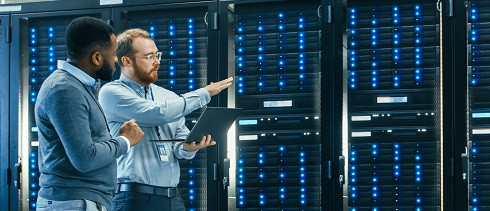 Two men walking next to servers.