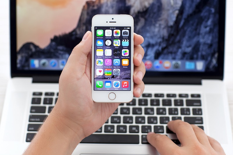 An iPhone in front of a laptop.