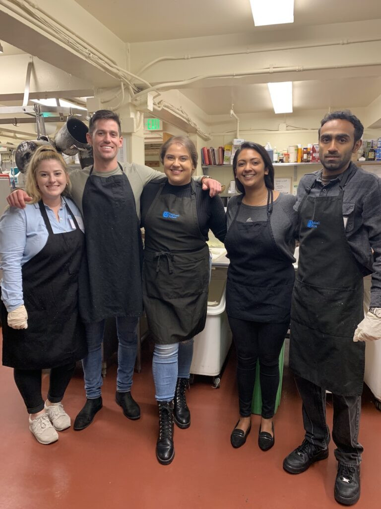 Canto Cares volunteers help prep a meal for families in need at Raphael House
